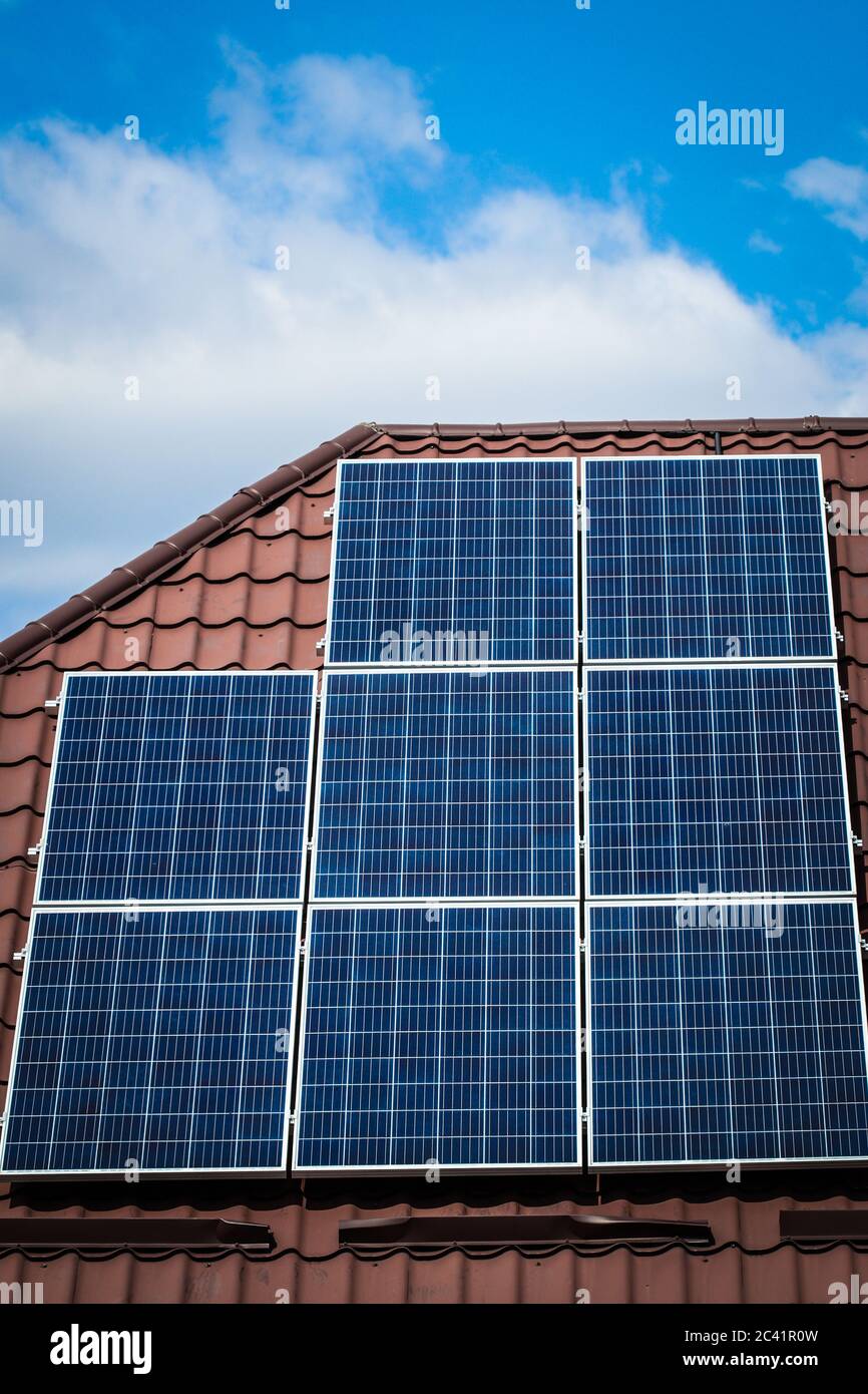 Solar panels mounted on attic roof of house Stock Photo