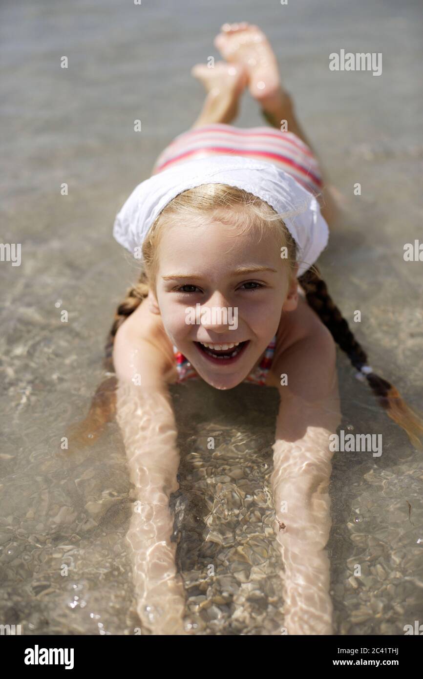 Girl lies in shallow water, laughs at the camera Stock Photo Alamy