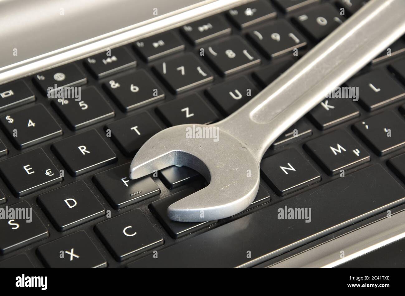 Wrench lying on computer keyboard symbolizing IT maintenance Stock Photo