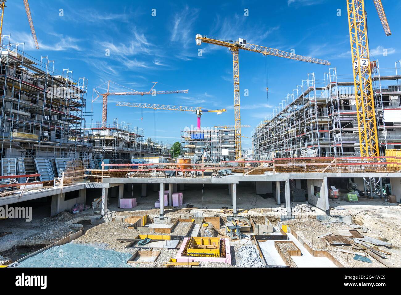 Large construction site with foundations, unfinished buildings and cranes Stock Photo
