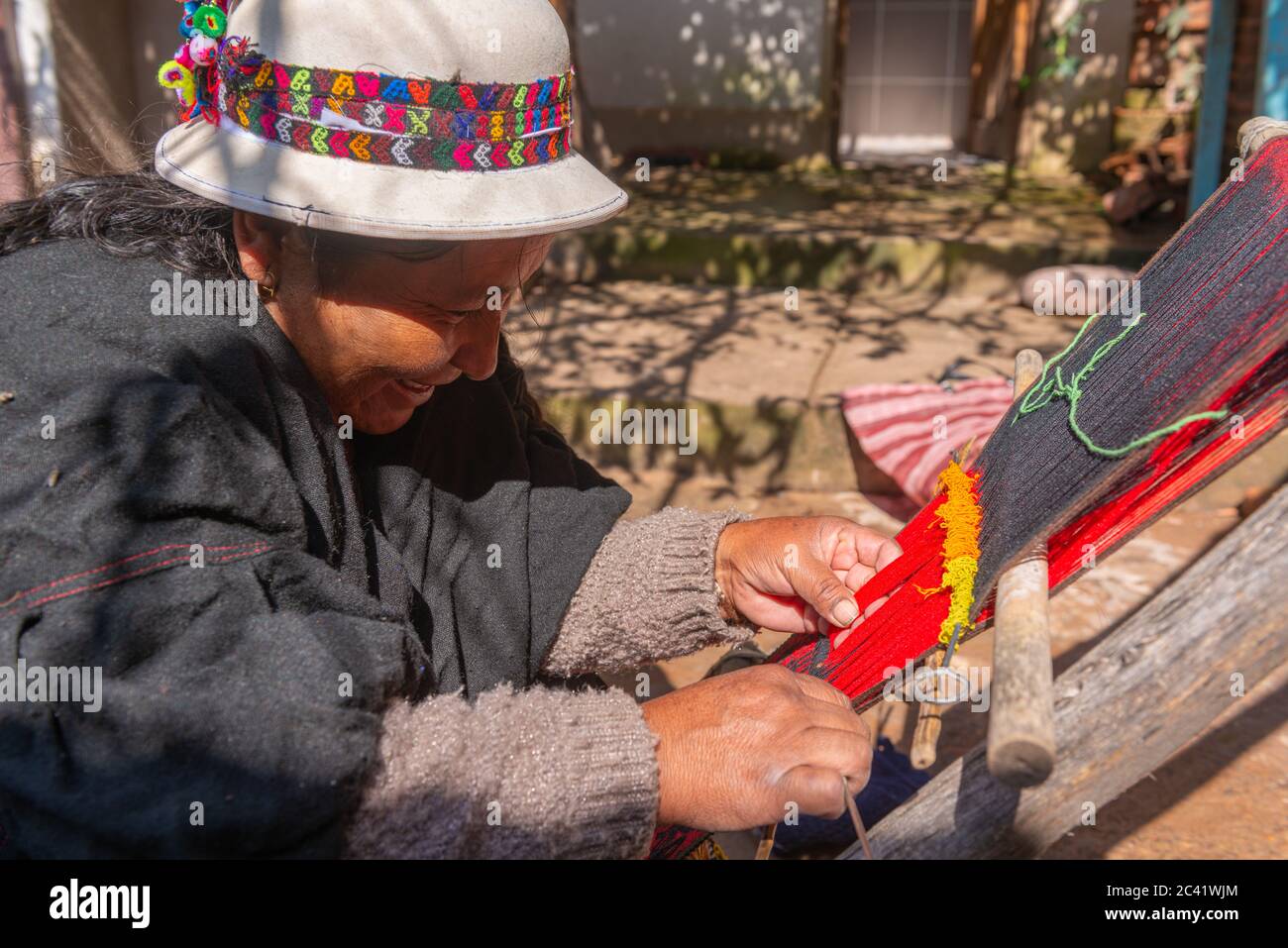 Elderly woman weaver weaving local red and black Jalq´a art pattern,  Potolo, Departamento Chuquisaca, Bolivia, Latin America Stock Photo