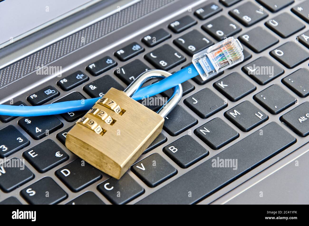 Internet cable and padlock on computer keyboard symbolizing data security Stock Photo