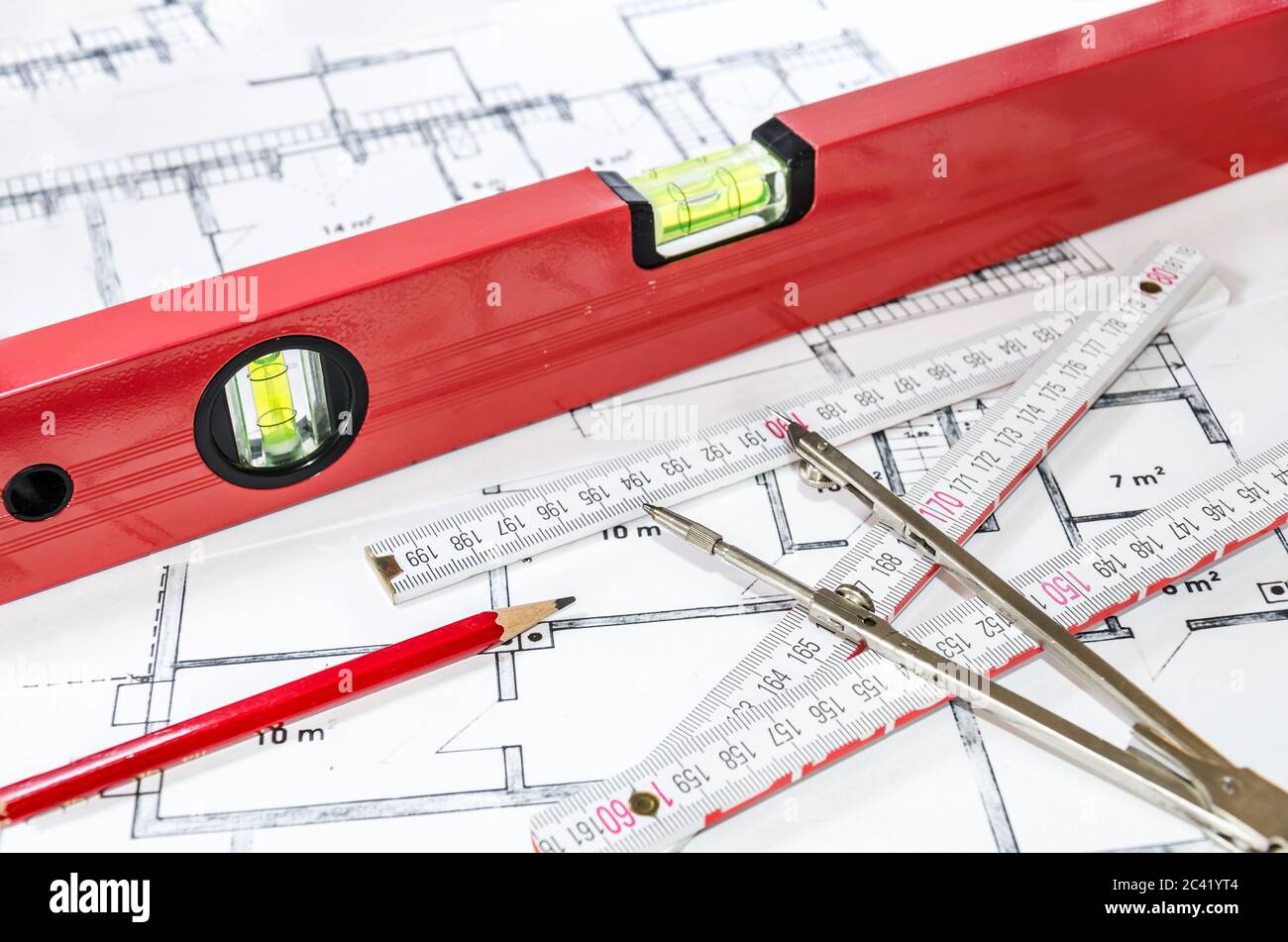 Spirit level, pencil, yardstick and compass calipers on a construction plan Stock Photo