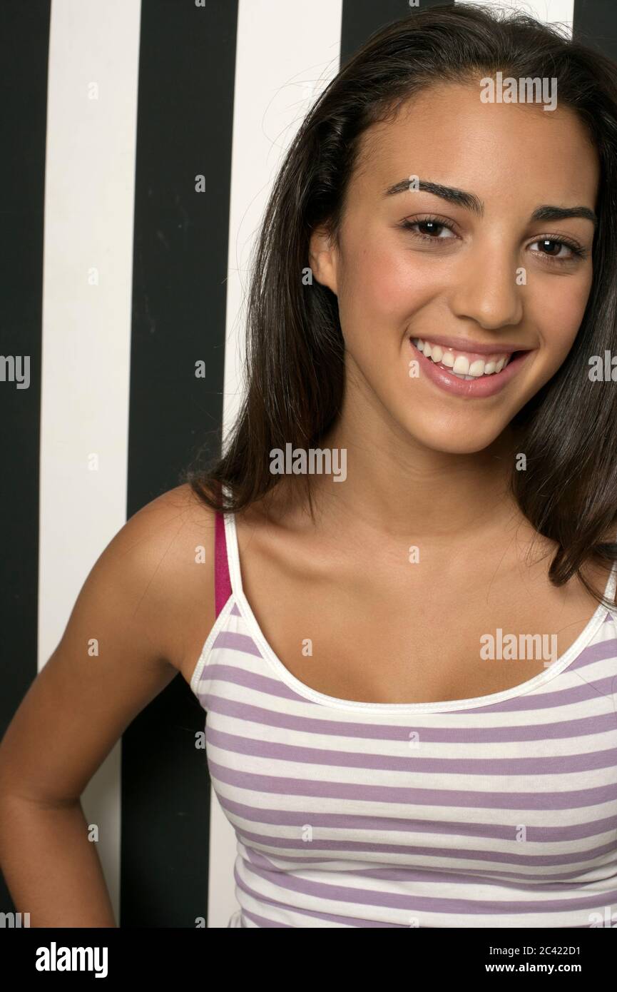 Portrait of a young woman in front of a striped wall Stock Photo - Alamy