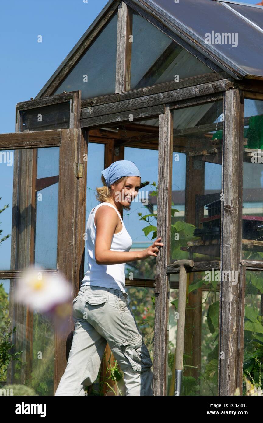 Young woman walks into a greenhouse Stock Photo - Alamy