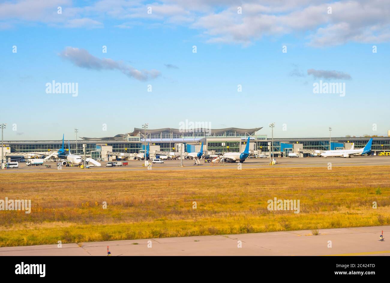 Airfield in sunshine, airplanes by the terminal modern building, Boryspil International Airport, Kyiv, Ukraine Stock Photo