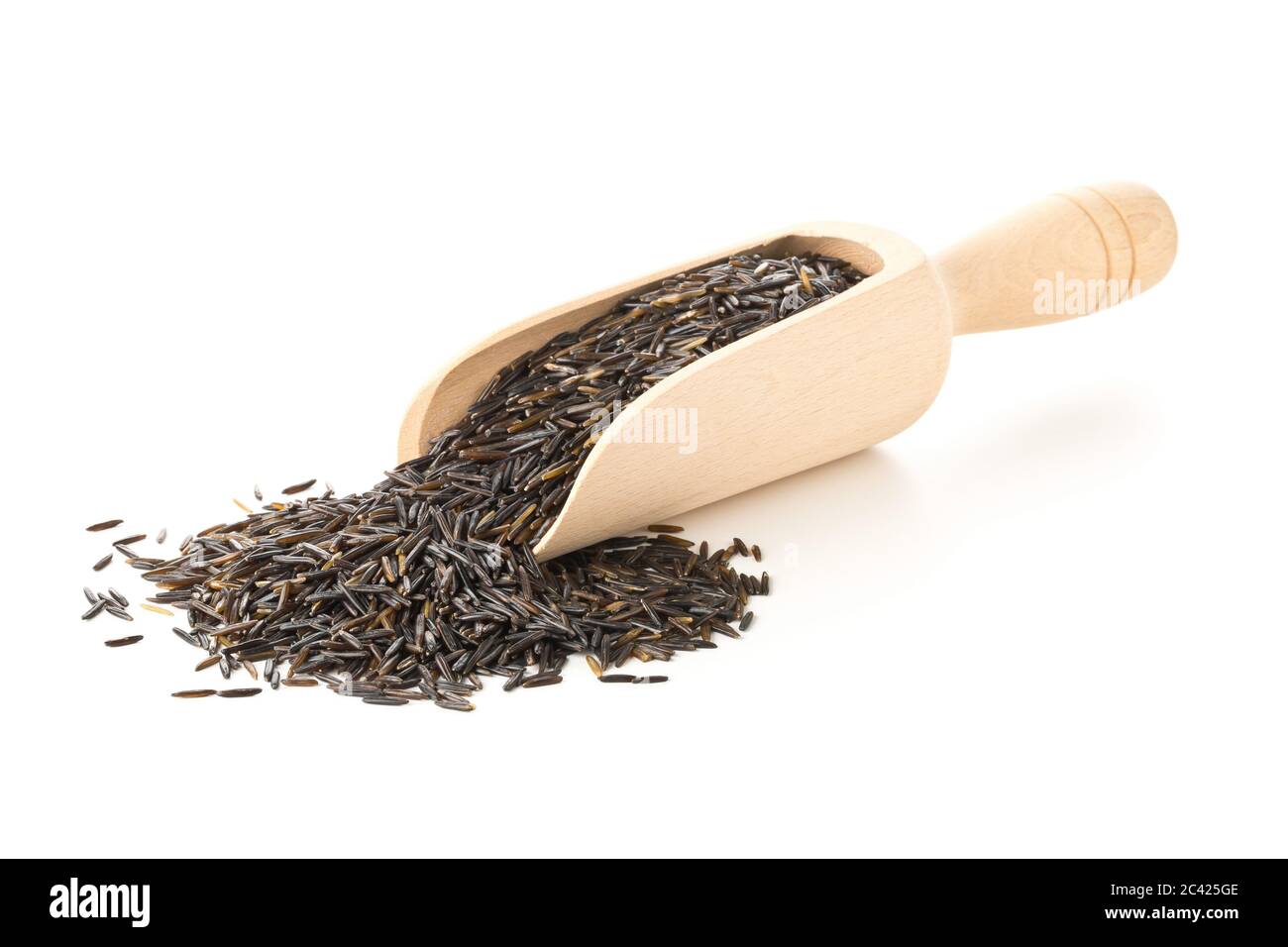 Heap of uncooked, raw, black wild rice grains in wooden scoop over white background, selective focus Stock Photo