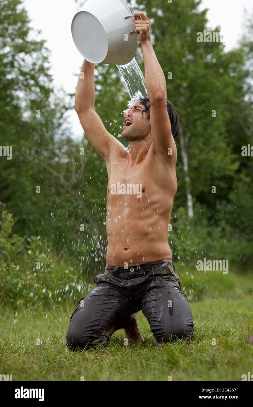 Young man pouring water over his head Stock Photo Alamy