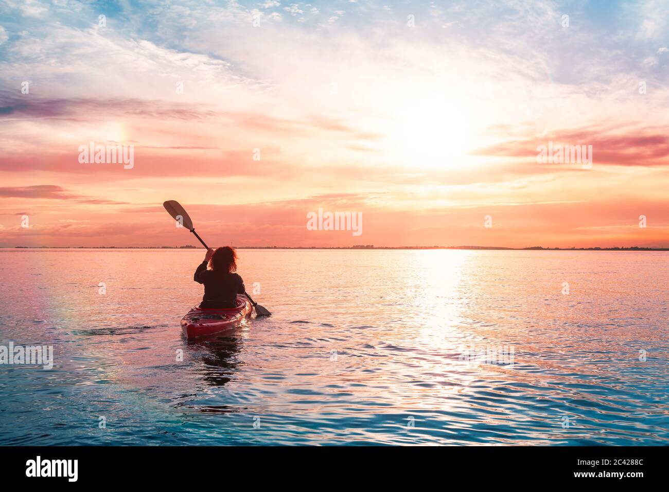 Sea Kayaking in calm waters during a colorful and vibrant sunset Stock ...