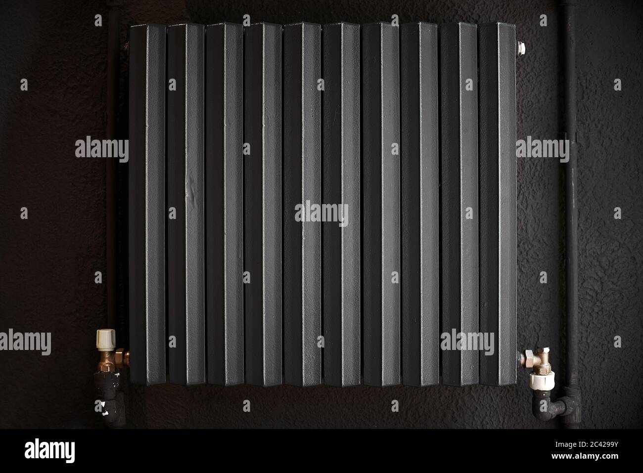 Cast iron radiator heater for home. Black heating battery on the black