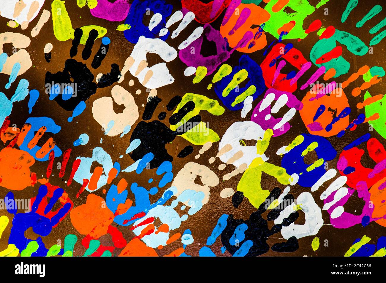 multi colored hands painted on wall going in same direction Stock Photo ...