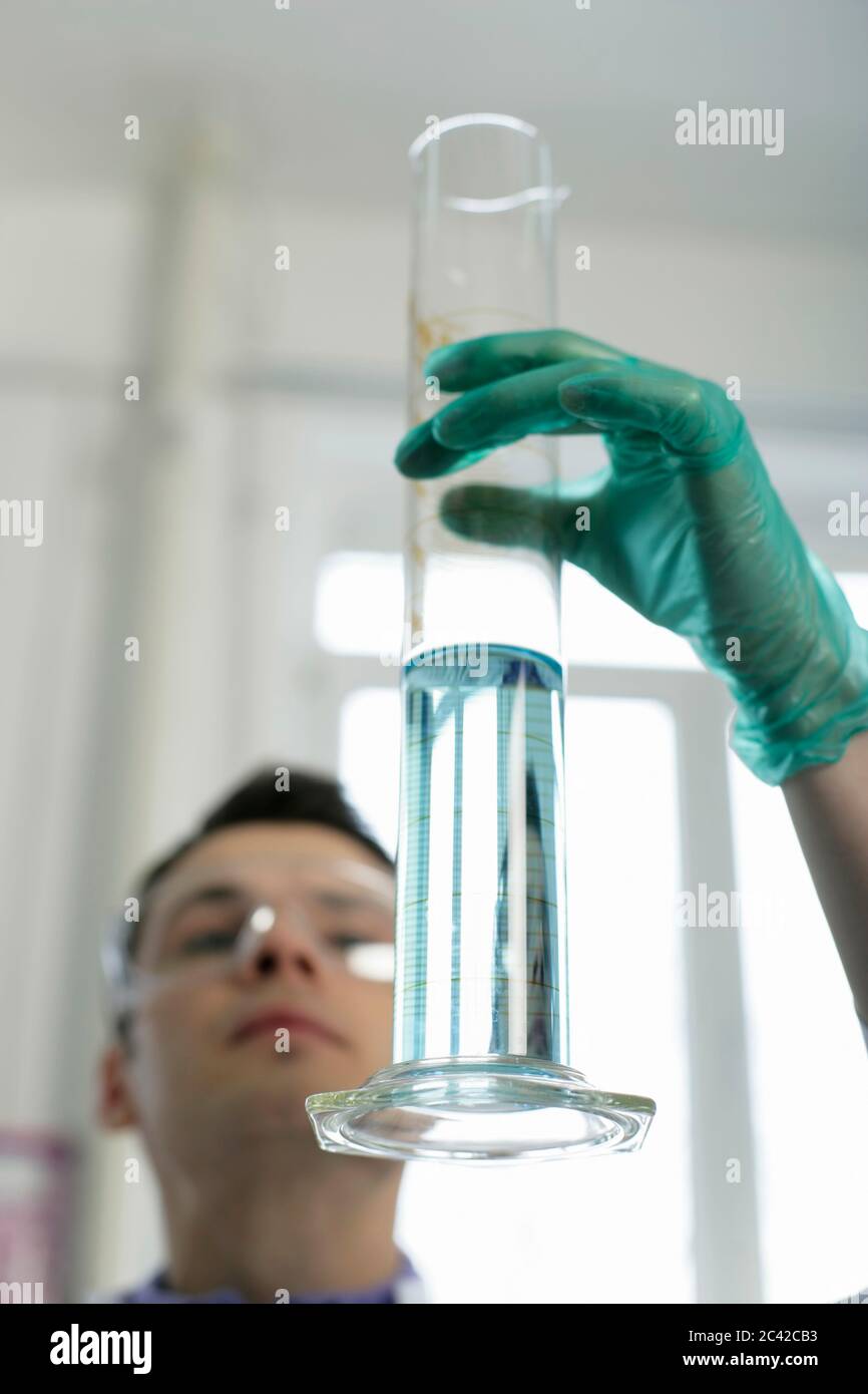 Laboratory technician measures liquid with a measuring cylinder Stock ...