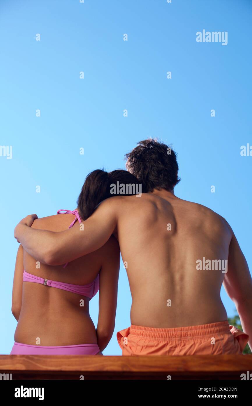 Young couple sitting side by side, rear view Stock Photo