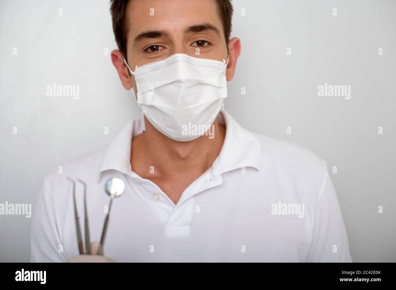 Dentist with face mask and dental examination equipment Stock Photo