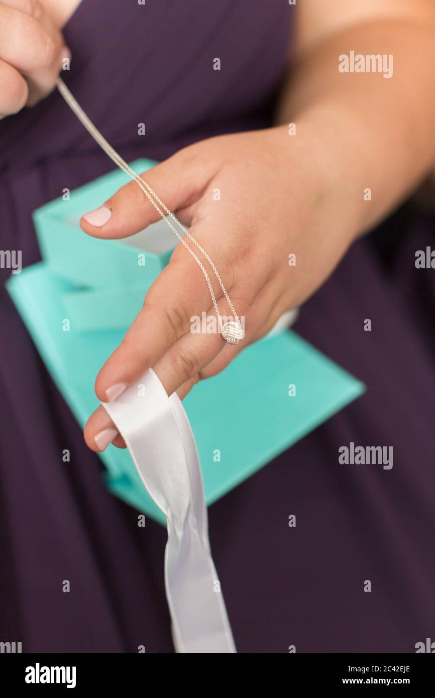 Woman holding diamond pendant over her hand Stock Photo