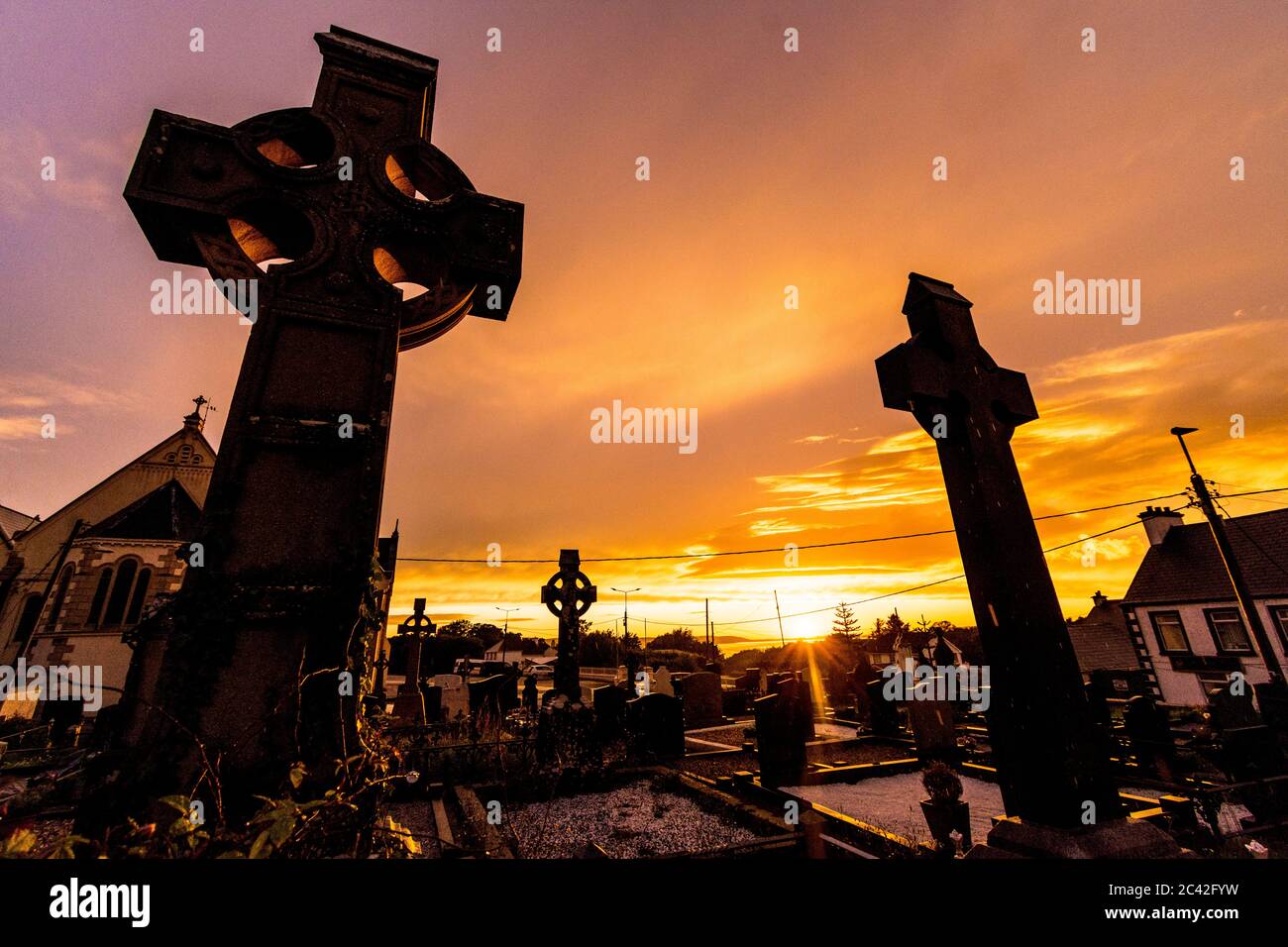 Ardara, County Donegal, Ireland weather. 23rd June 2020. A spectacular sunset over the graveyard of the Church of the Holy Family on the west coast. The weather had been changable all day with some heavy rainfall. Stock Photo