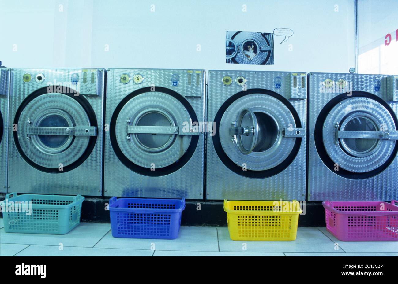 Colorful laundry baskets in front of washing machines structure
