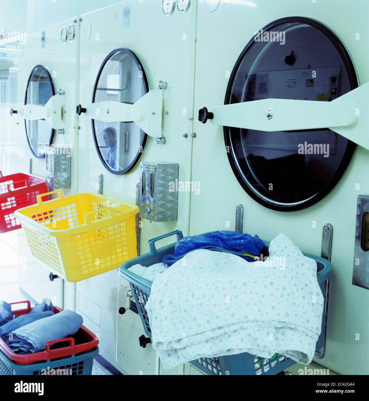 Colorful laundry baskets in front of washing machines structure