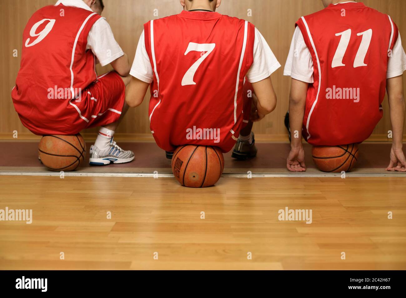Three basketball players sit on balls Stock Photo Alamy