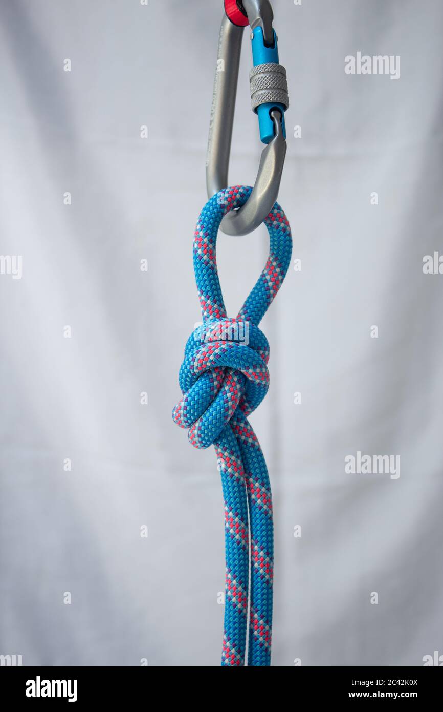 Overhand knot tied with a climbing rope to a pear shaped locking carabiner Stock Photo