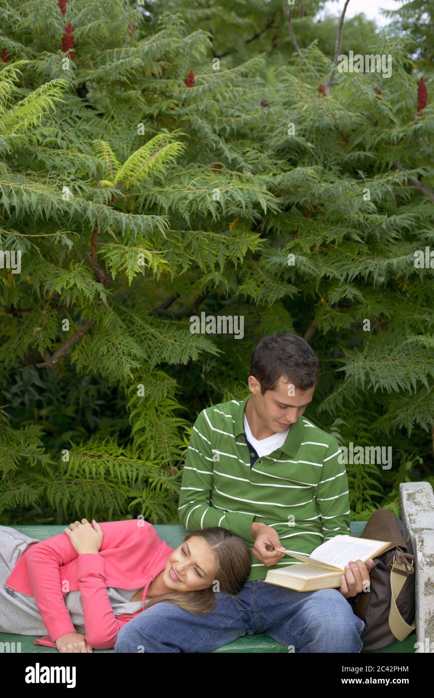 Young couple on park bench Stock Photo - Alamy