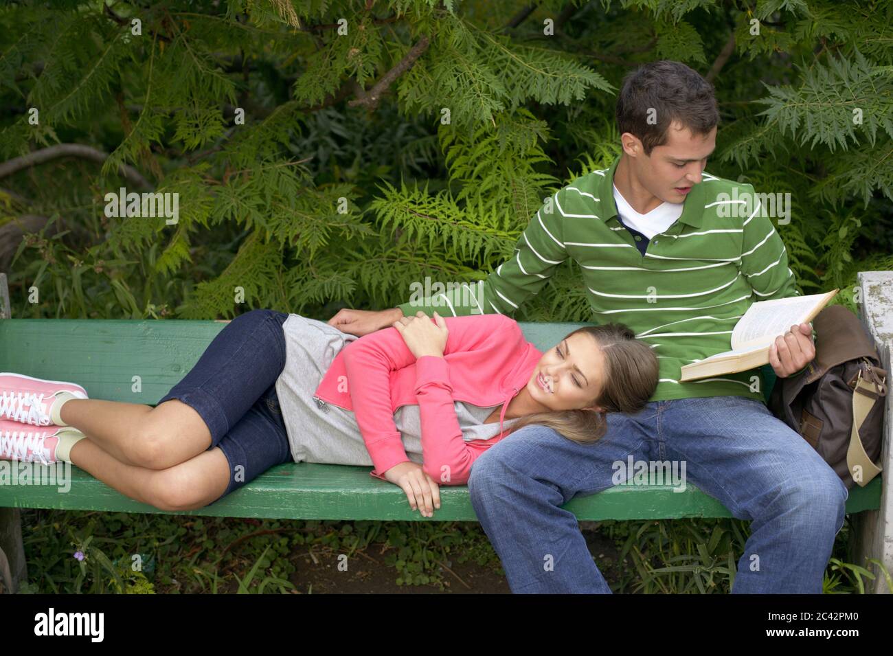 Young couple on park bench Stock Photo - Alamy
