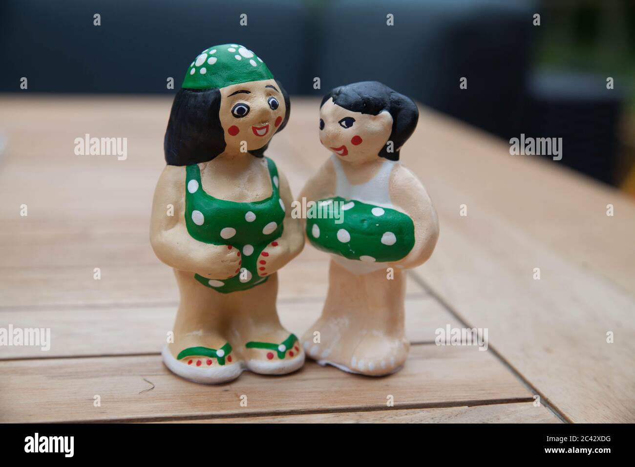 Parenting: Two figurines showing a woman and her teenage daughter wearing swimsuits and talking to each other with trust and confidentiality. Stock Photo