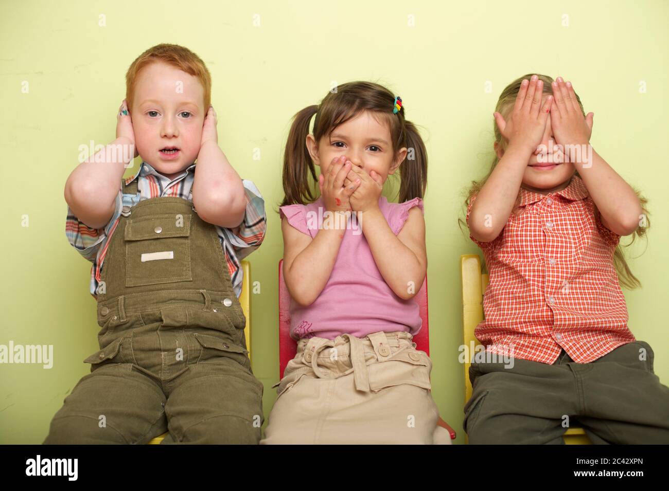 Three children (45 years) cover their ears, mouth and eyes Stock Photo