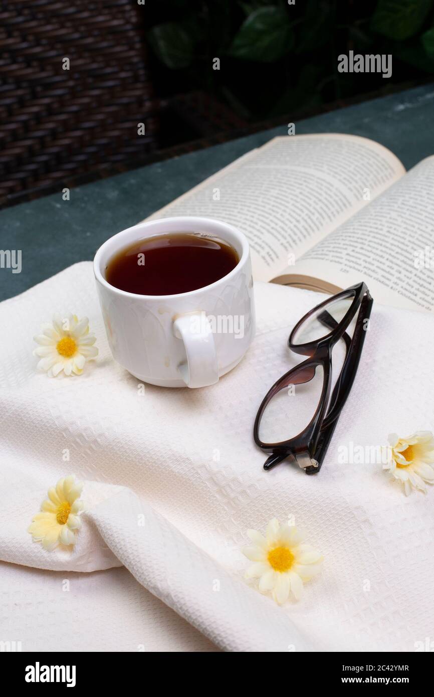 A cup of tea, optique glasses and a book Stock Photo