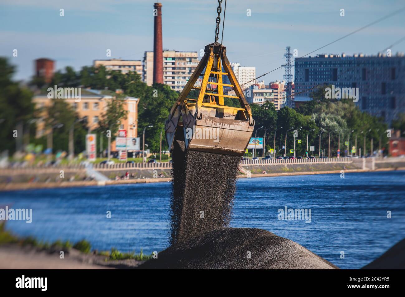 Bulk-handling crane unloading sand, road metal and gravel from cargo ...