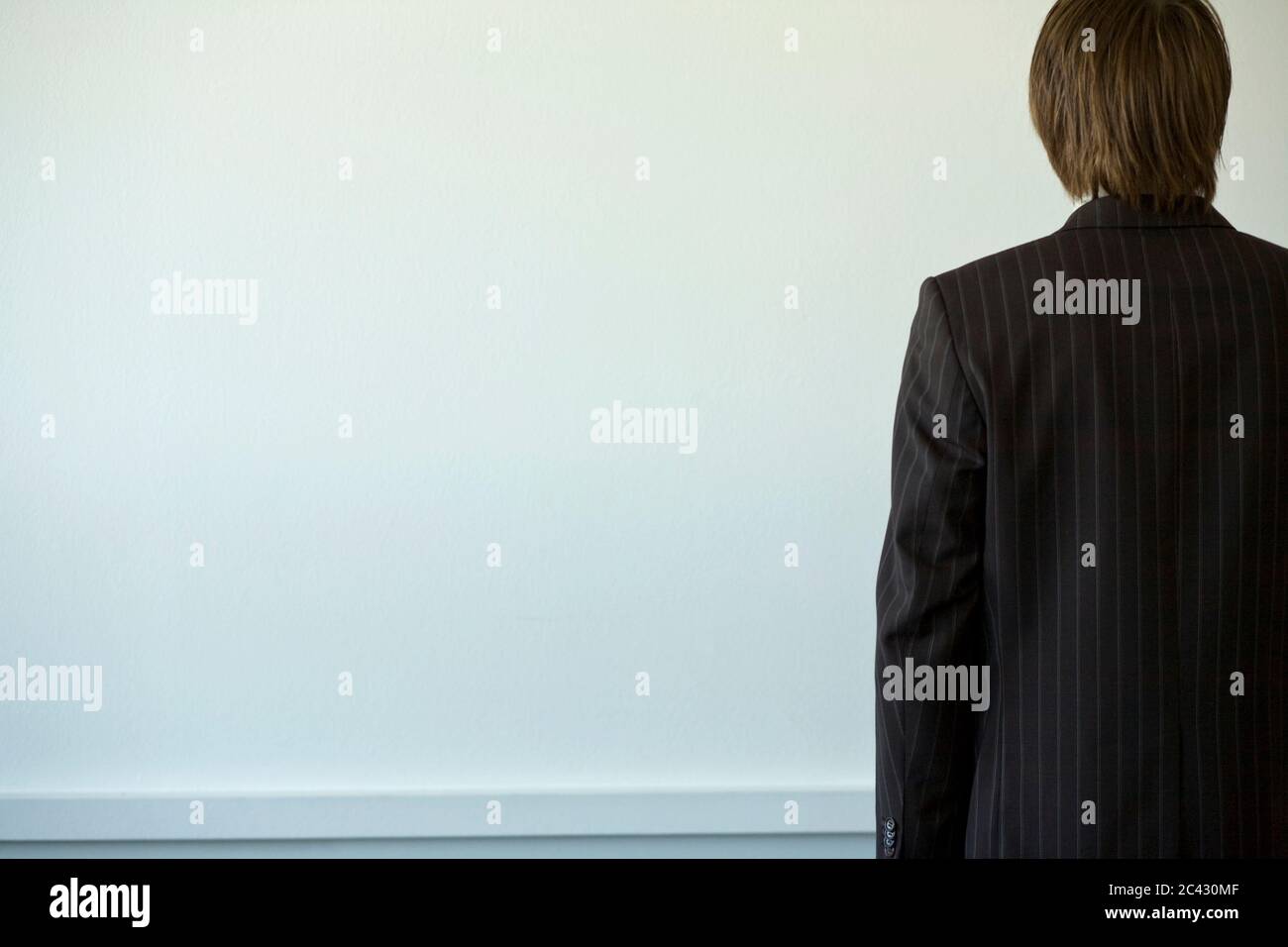 Man in front of a white wall Stock Photo - Alamy