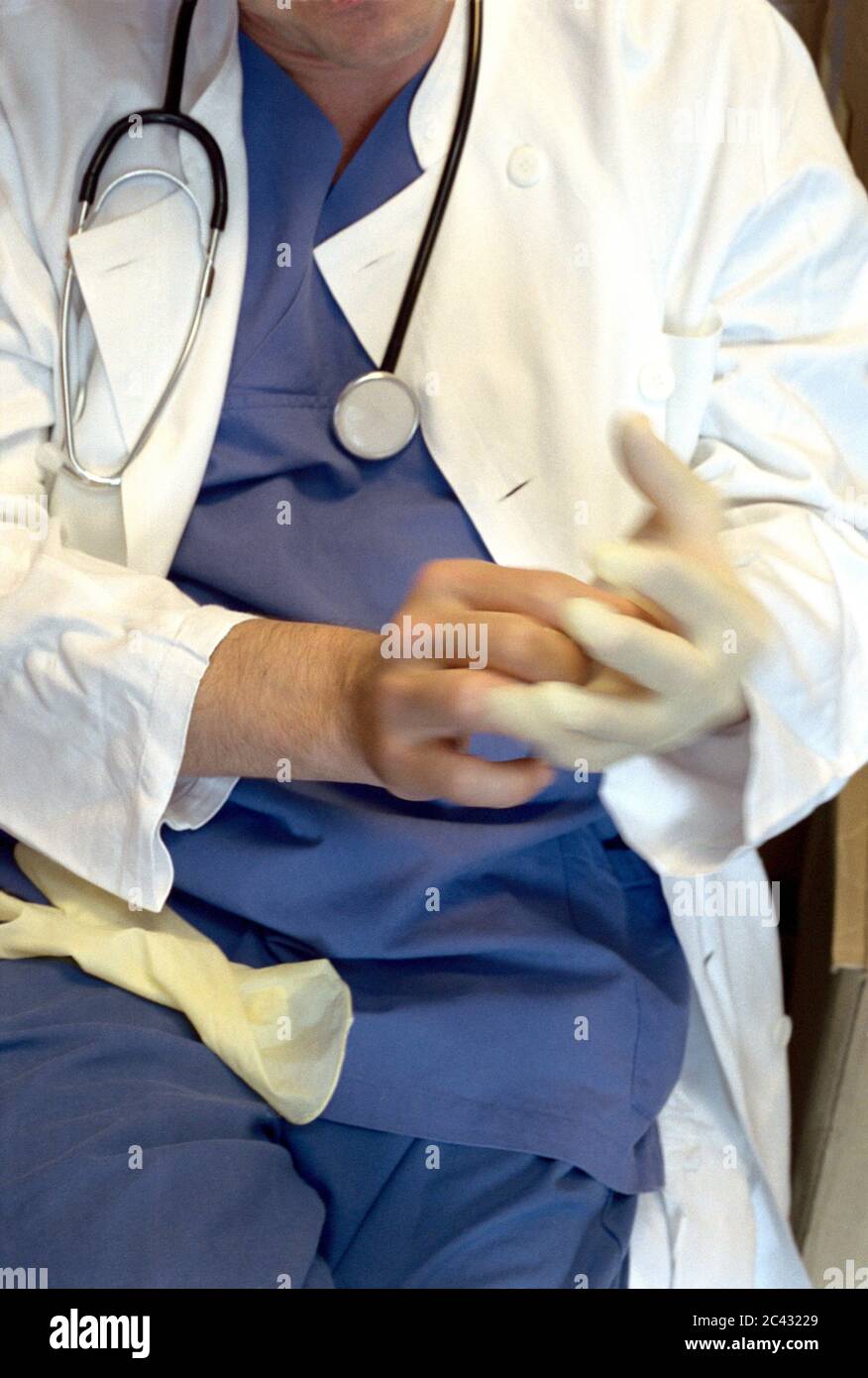 Doctor puts on disposable gloves - hospital Stock Photo
