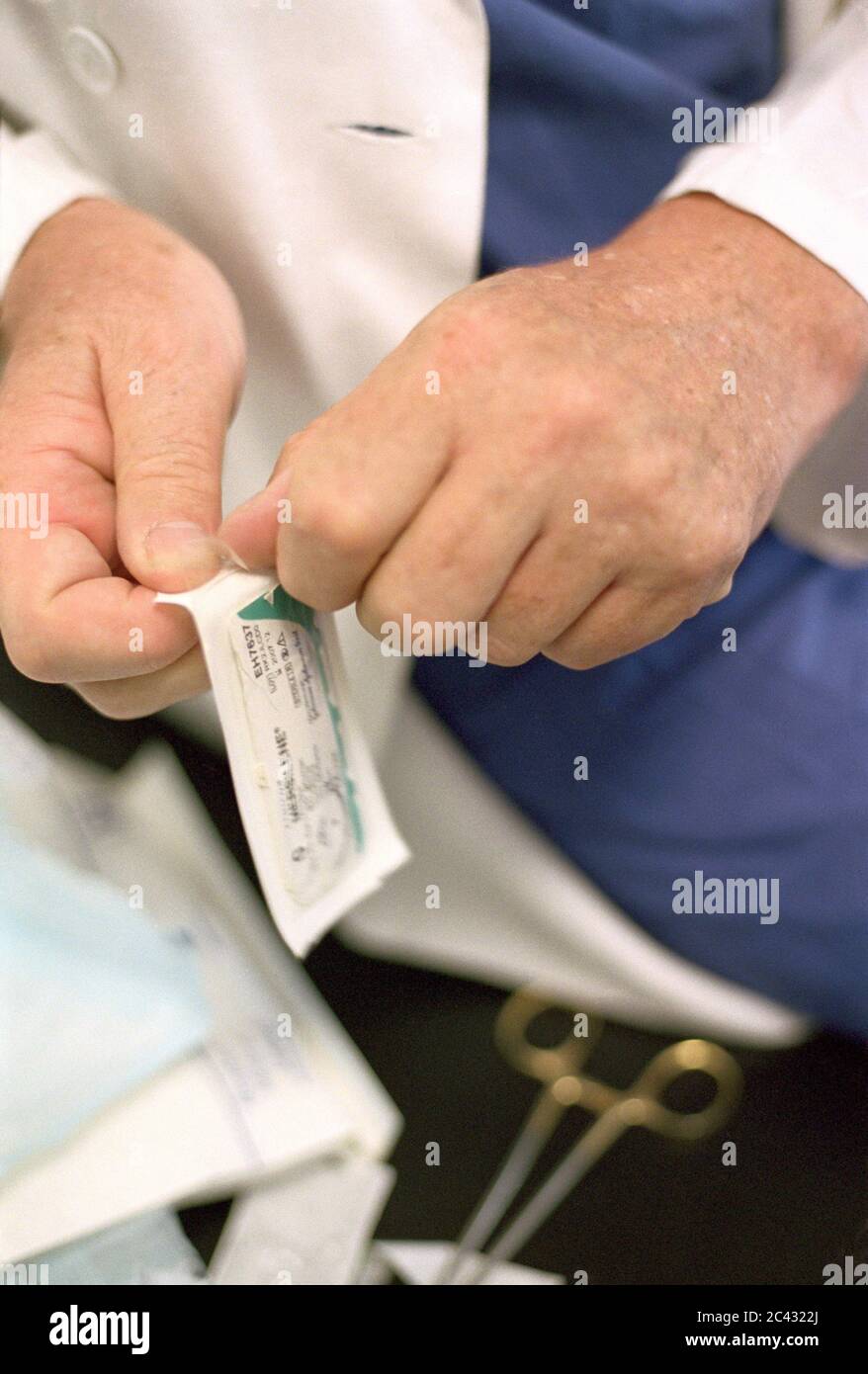 Doctor unpacks bandages (detail) - hospital Stock Photo