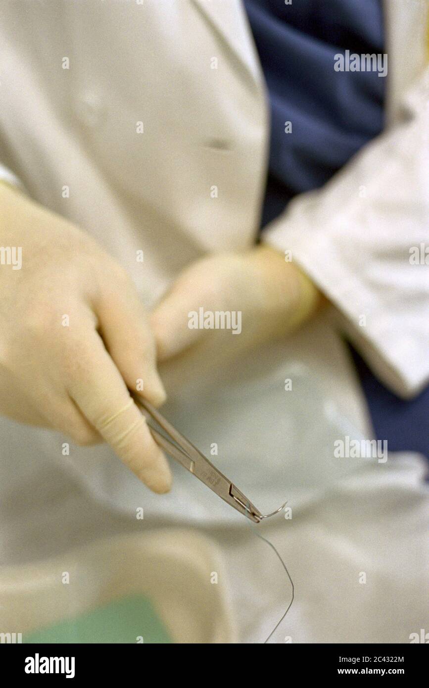 Doctor with surgical needle (detail) - hospital Stock Photo