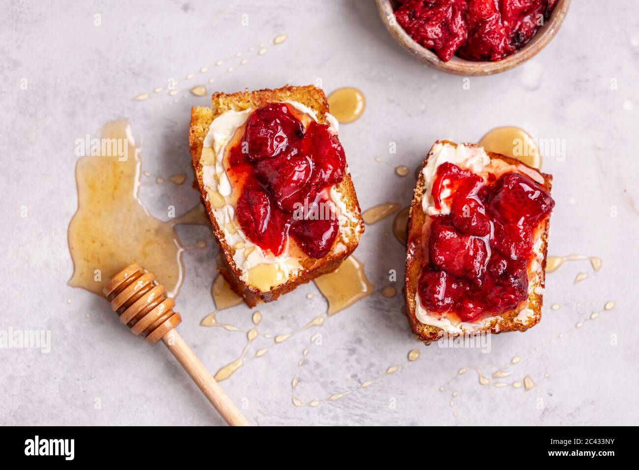 Corn bread toast with butter, roasted strawberries and honey Stock Photo