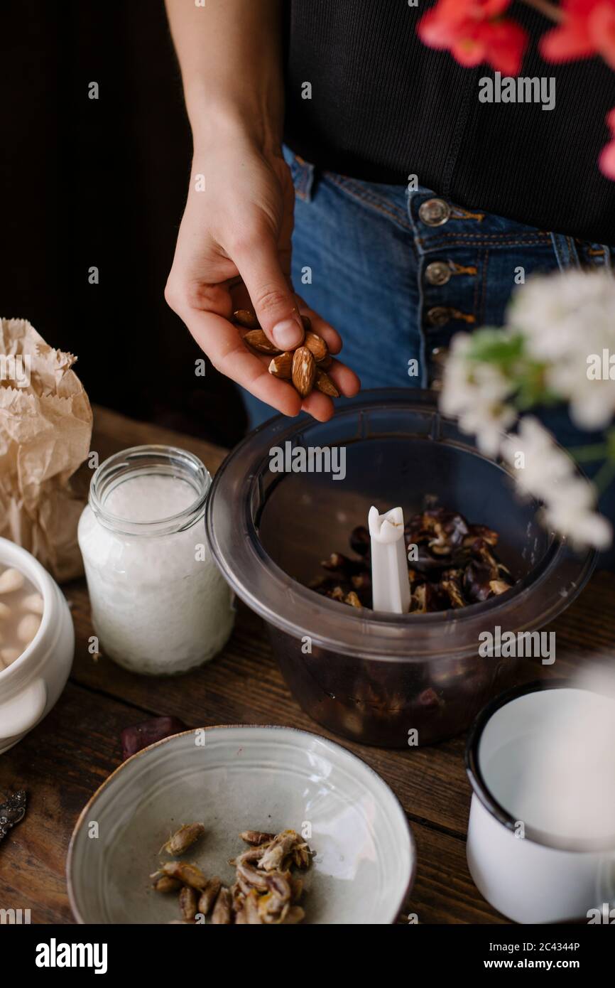 Adding nuts and dates to a blender Stock Photo Alamy