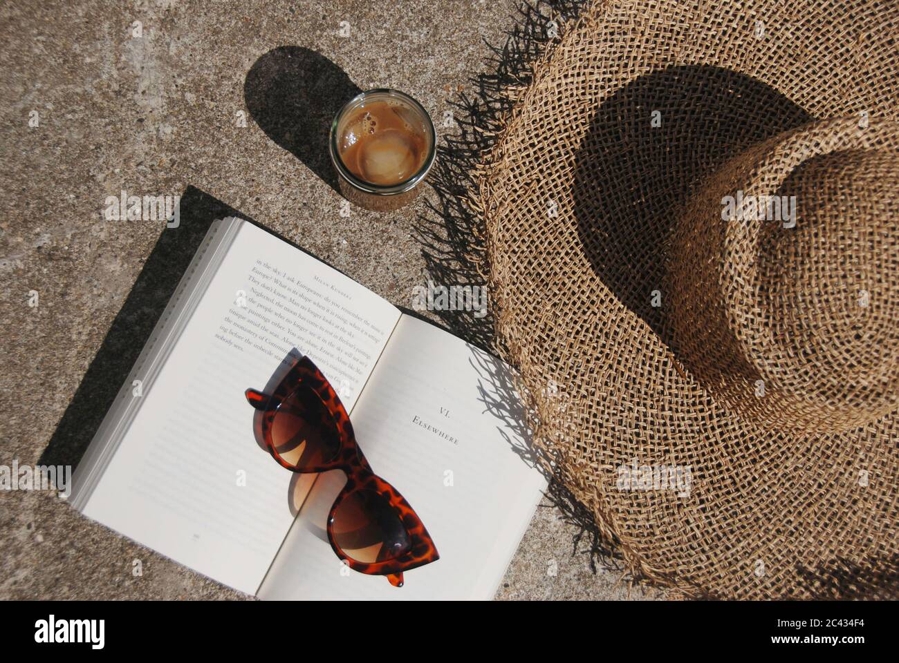 Straw Hat and book on the terrace Stock Photo - Alamy
