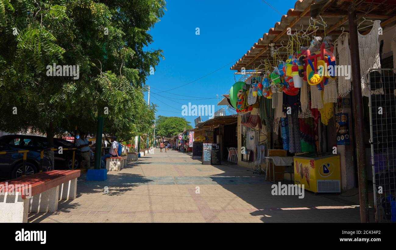 Mancora, Piura / Peru - April 10 2019: Tourists walking on a street full of craft vendors next to the main avenue of the town Stock Photo