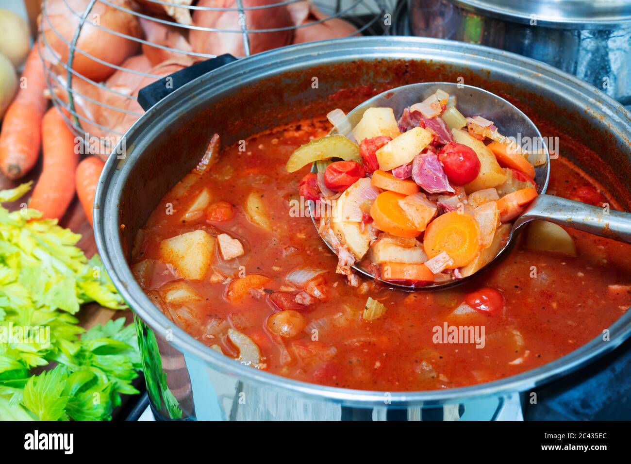 Vegetable and ham hock soup in a pot. Stock Photo
