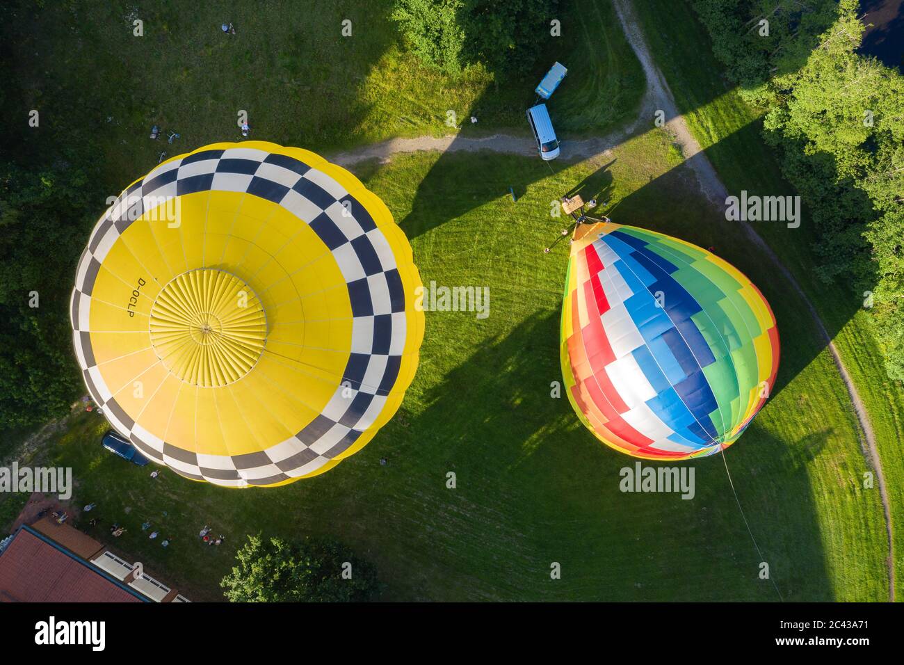 Cloppenburg, Germany. 23rd June, 2020. Two hot-air balloons, in the left one the band 'Crackerjacks', who have planned a concert from the balloon over Cloppenburg, are about to take off on a meadow. (recording with a drone) Credit: Mohssen Assanimoghaddam/dpa/Alamy Live News Stock Photo