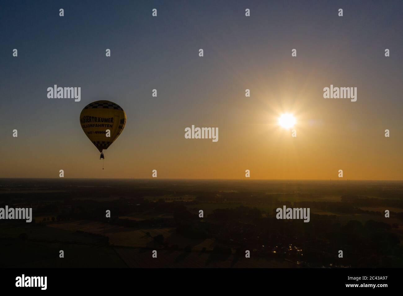 Cloppenburg, Germany. 23rd June, 2020. The band 'Crackerjacks' rides in a hot air balloon over Cloppenburg before the setting sun and gives a balloon concert. (Recording with a drone) Credit: Mohssen Assanimoghaddam/dpa/Alamy Live News Stock Photo