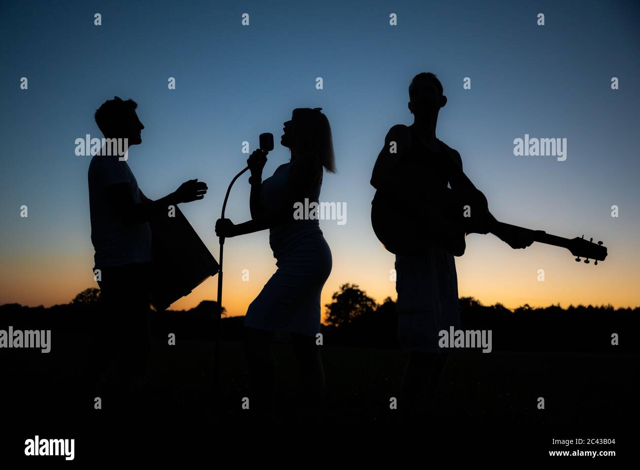 Cloppenburg, Germany. 23rd June, 2020. The silhouettes of the members of the band 'Crackerjacks' stand out against the sky during sunset. Shortly before, the band held a balloon concert over Cloppenburg. Credit: Mohssen Assanimoghaddam/dpa/Alamy Live News Stock Photo