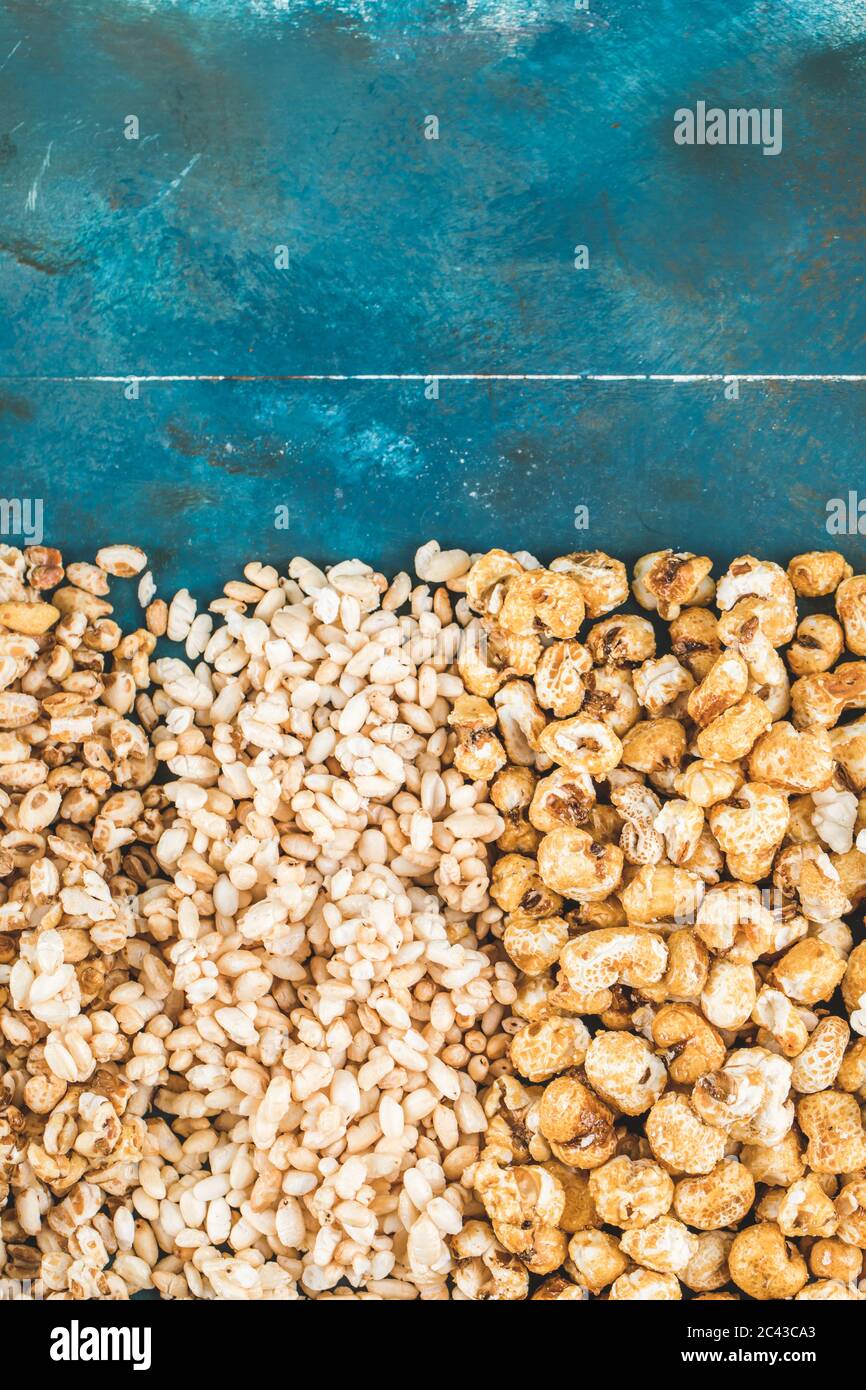 Popcorn , caramel corn and wheat corn on blue background Stock Photo