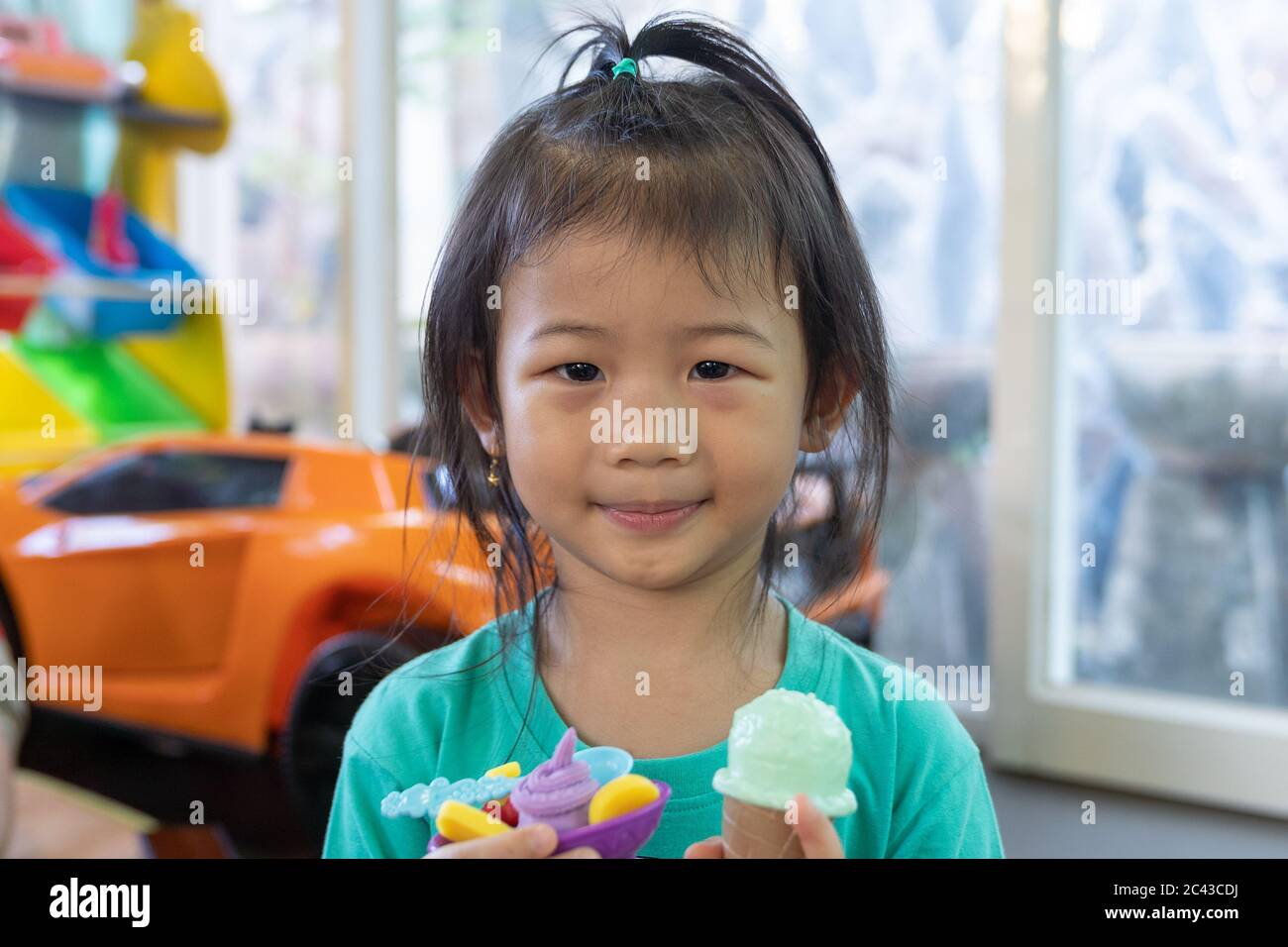 Portrait of small girl. Asian cute little girl play icecream toy stay at home. Stock Photo
