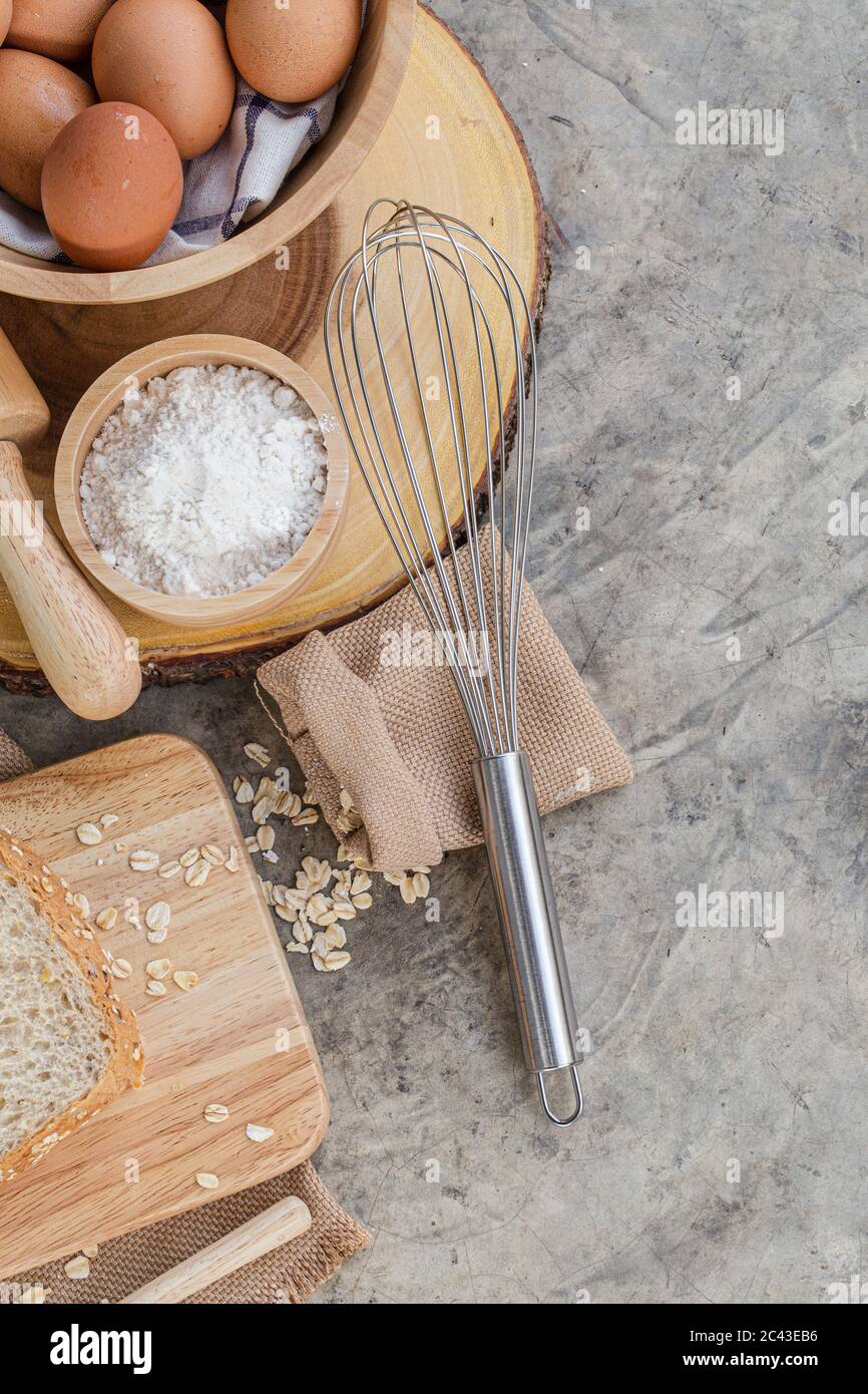 Baking Cooking Ingredients Flour Eggs Rolling whisk And roll oat On Bright Grey Concrete Background. Top View Copy Space. Stock Photo