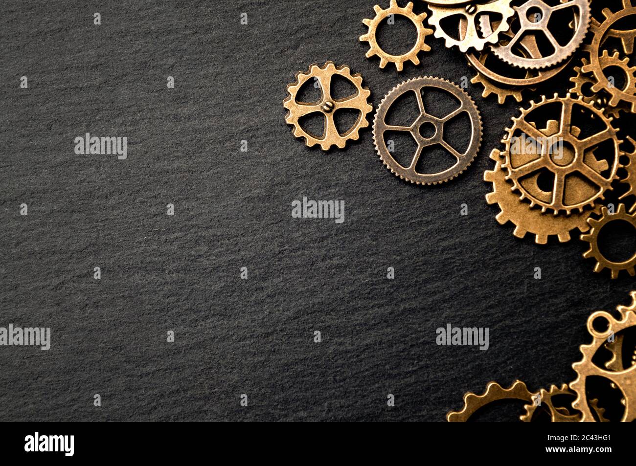 Steampunk accessories and old technology conceptual idea with border made of a group brass cog wheels on dark texture background with copy space Stock Photo