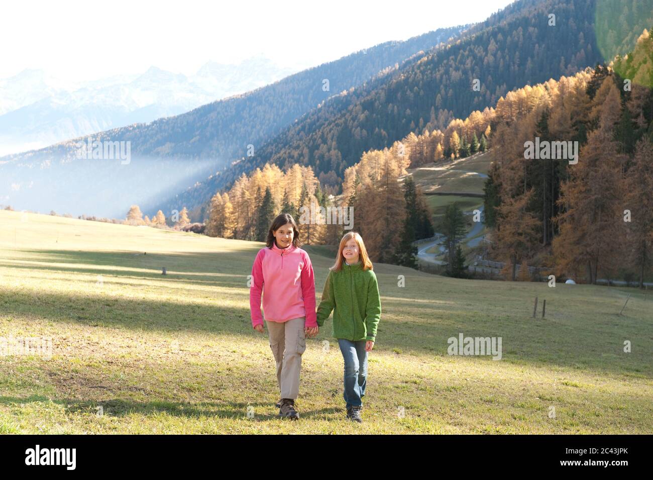 Two girls go for a walk hand in hand, Tyrol, Austria Stock Photo