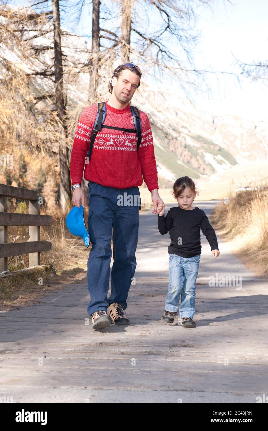 Father and daughter go for a walk hand in hand, Tyrol, Austria Stock Photo