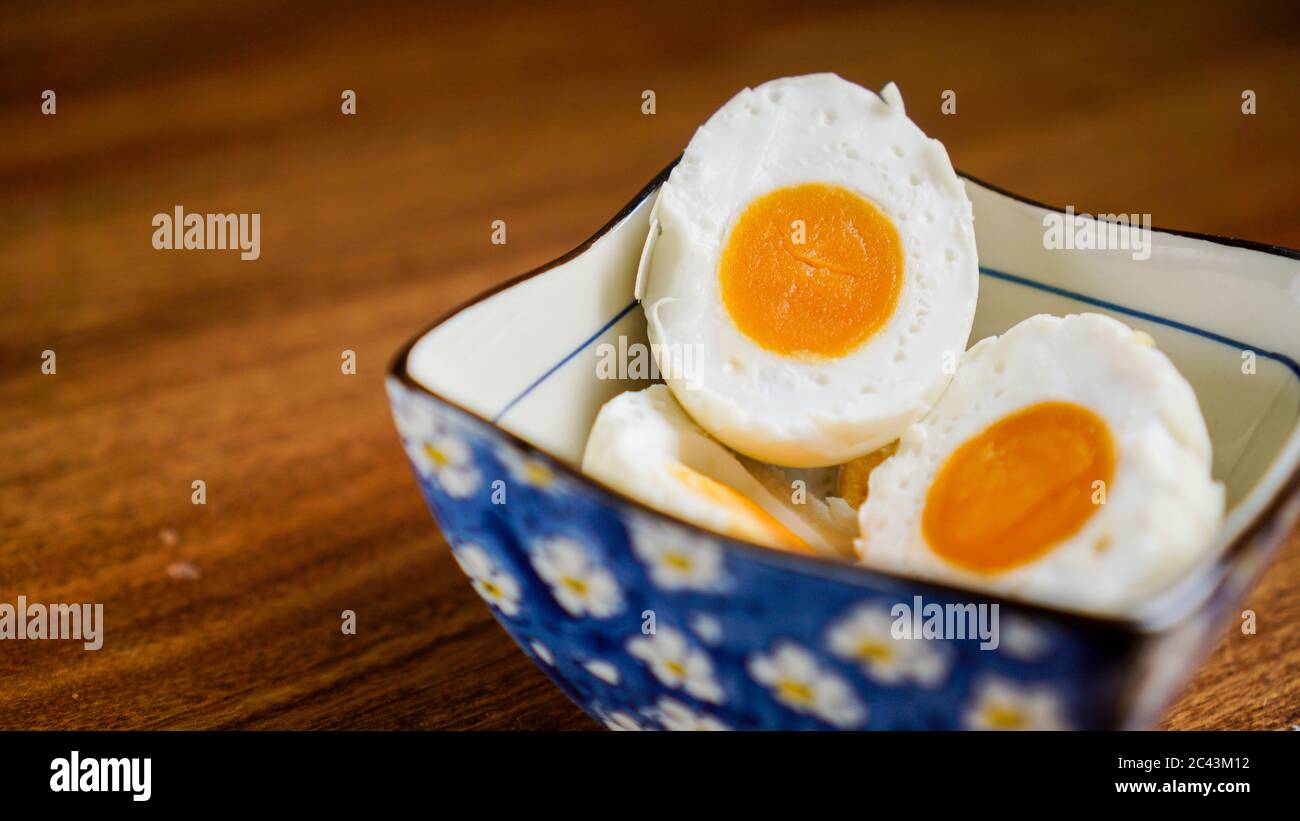 A salted duck egg is a Chinese preserved food product made by soaking duck eggs in brine, or packing each egg in damp, salted charcoal. Salted duck eg Stock Photo