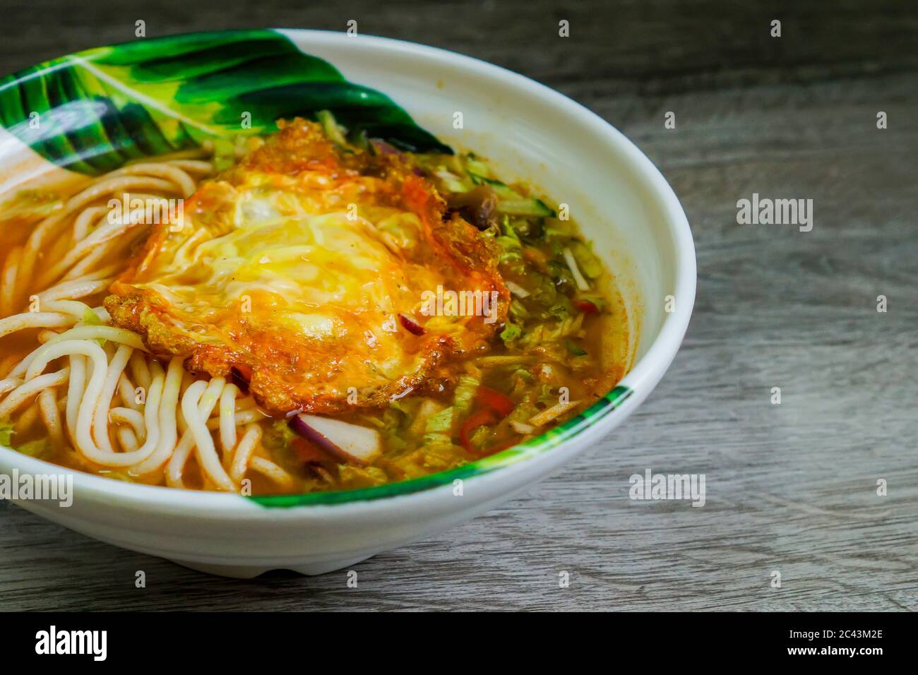 Traditional laksa from nothern Malaysia with a little twist. Serve with fried egg instead of boiled egg. Stock Photo